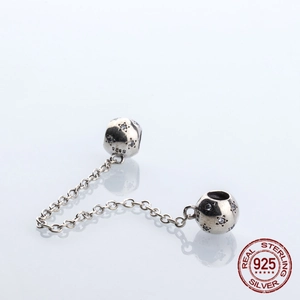 Detalle de cadena de seguridad de plata S925 con dijes de estrellas y circonitas