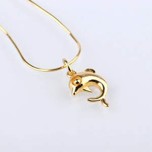 Gedetailleerd beeld van een gouden dolfijn hanger aan een slangenketting