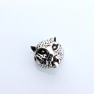 Detailed close-up of a leopard head charm bead made of antique silver metal for DIY jewelry