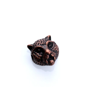 Detailed macro view of leopard head metal bead with vintage bronze finish for jewelry DIY