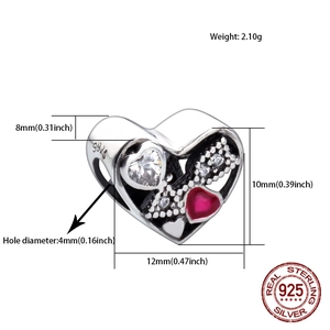 Macro shot of S925 sterling silver heart charm with red enamel and white zircon stones