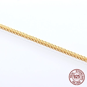 Detail of 925 sterling silver gold-plated wheat chain with elegant braided metal texture