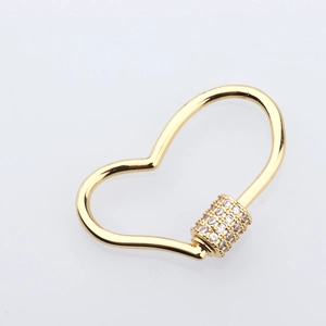 Close-up of heart-shaped screw clasp with sparkling zircon stones in gold plating