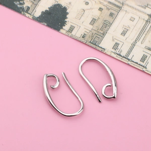 Close-up of minimalist silver plated hypoallergenic ear hooks on a pink background