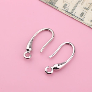 Close-up of polished silver earring hooks for DIY jewelry making on pink background