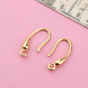 Macro shot of gold-plated curved ear hooks with teardrop ends and loops for DIY jewelry