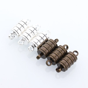 Detail of cylindrical magnetic jewelry clasps with non-slip texture in silver and bronze