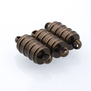 Macro detail of cylindrical magnetic bronze jewelry clasps with spiral texture for DIY