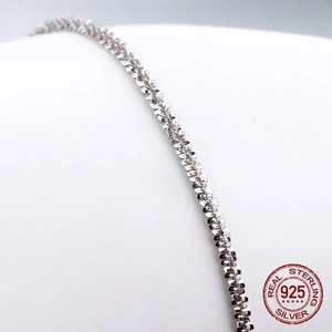 Macro detail of S925 sterling silver chain with intricate flat micro-engraved link patterns