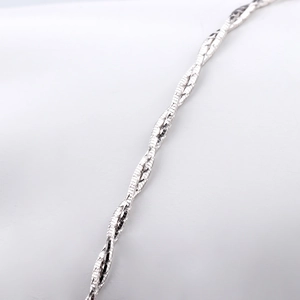 Macro shot of polished S925 sterling silver chain with unique twisted snake bone pattern