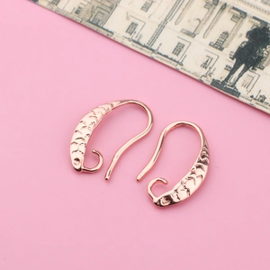 Detail showing rose gold DIY earring hooks with intricate textured pattern for jewelry making