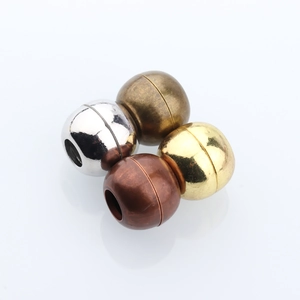 Macro view of four-color spherical magnetic jewelry clasps in gold silver and bronze