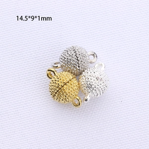 Dettaglio macro di chiusure magnetiche sferiche con finitura oro e argento lucido