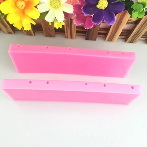 Pink rectangular silicone lollipop mold with relief numbers for cake decorating