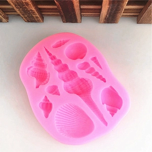 Pink silicone mold featuring various ocean seashells and conch shapes for cake decorating
