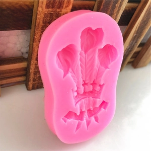 Pink silicone mold featuring intricate feather and crown relief for DIY cake decorating