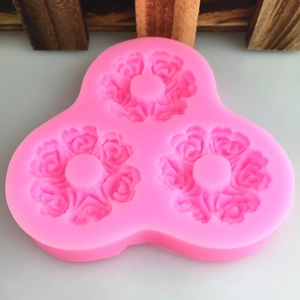 Pink silicone mold featuring three cavities with detailed rose floral patterns for DIY cakes