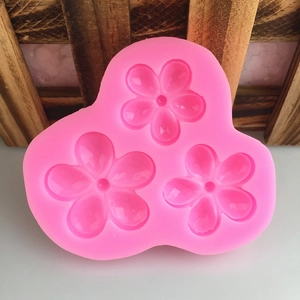 Pink silicone mold with three five-petal flower shapes for chocolate and fondant cake decor