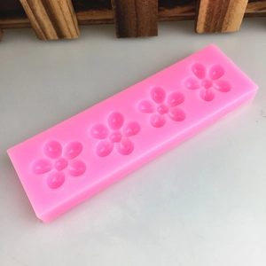 Pink silicone mold featuring four flower-shaped cavities for handmade soap and cakes