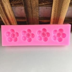 Pink 4-cavity silicone mold with spiral flower patterns for DIY baking and fondant crafts