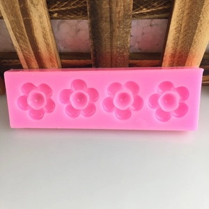 Pink silicone mold featuring four flower-shaped cavities for DIY baking and handmade crafts