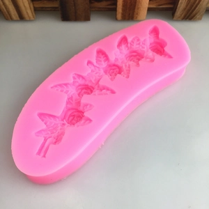 Pink silicone mold featuring intricate 5-flower rose and vine leaf patterns for DIY cakes