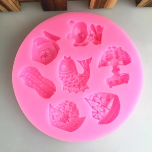 Pink silicone mold featuring traditional Chinese New Year patterns like carp and peanuts