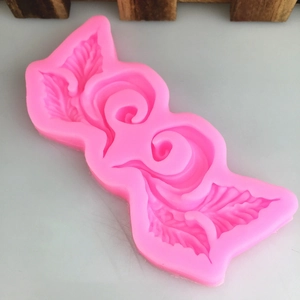 Pink silicone vine mold with symmetrical leaf scroll design for fondant cake decorating