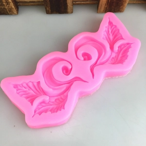 Pink silicone fondant mold with symmetrical vine and leaf scroll patterns for cake DIY