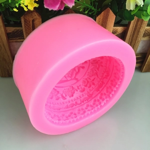 Pink round liquid silicone mold with intricate floral relief patterns for DIY crafts