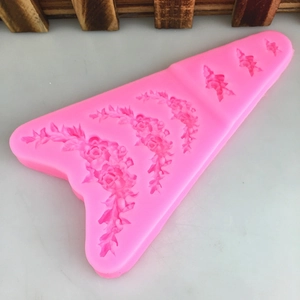 Pink silicone mold featuring various rose and leaf designs for fondant cake decorating