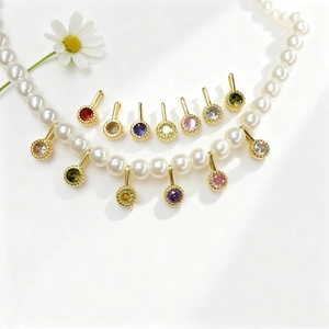 Macro view of gold-plated pendant with multi-color cubic zirconia and cream pearls