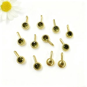 Close-up of olive green zircon charms with gold beaded edges for DIY jewelry making