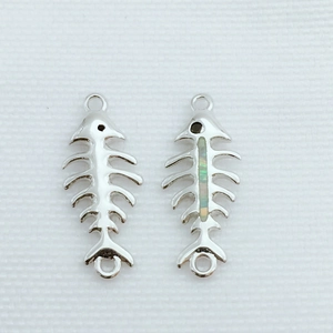 Detalle macro de colgantes de espina de pescado plateados con incrustaciones de ópalo para DIY