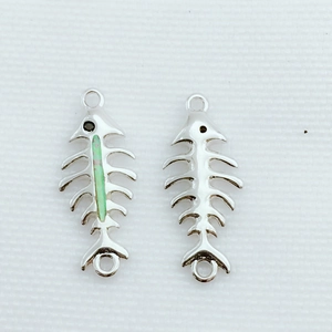 Vista macro de conectores de joyería en forma de espina de pez con opale sintético y plata