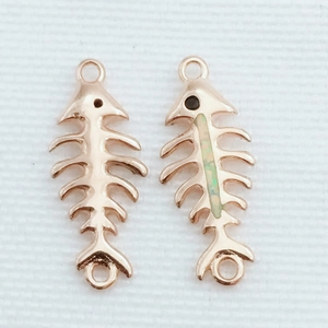 Detalle macro del colgante de espina de pescado en oro rosa con piedra de ópalo