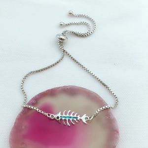 Detalle de pulsera de espina de pescado plateada con ópalo azul y cadena ajustable
