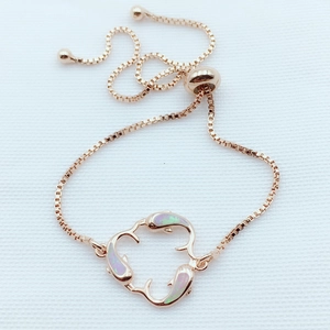 Detail of rose gold dolphin bracelet with opal inlay and adjustable bolo slide clasp
