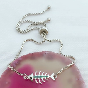 Detalle de pulsera con dije de opalo de espina de pescado y cadena de caja ajustable