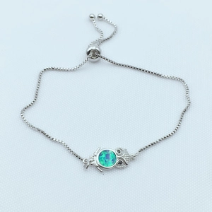 Detail of owl connector with blue-green opal stone and adjustable box chain bracelet