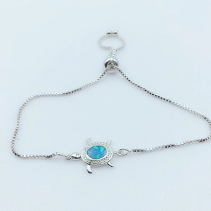 Détail du bracelet tortue avec coque en opale synthétique et fermoir à perle ajustable