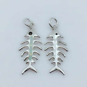 Detail view of gold and silver fishbone pendants with inlaid blue opal for DIY jewelry