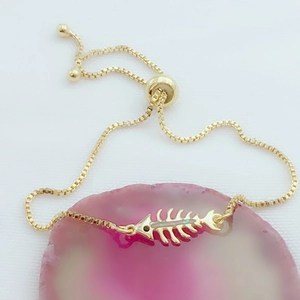 Detalle de pulsera ajustable de espina de pez dorada con ópalo sobre ágata rosa