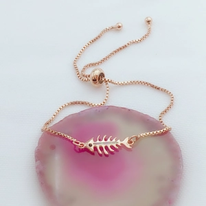 Detalle de pulsera de espina de pez en oro rosa con incrustación de ópalo iridiscente