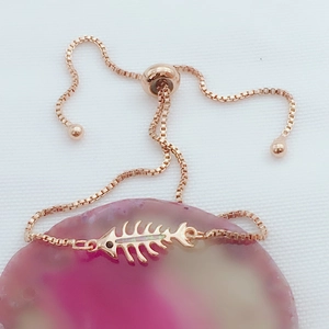 Detalle de pulsera de espina de pez en oro rosa con cadena box y cierre ajustable tipo bolo