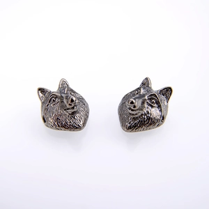 Detail of vintage wolf head stud earrings in antique silver finish with textured fur details