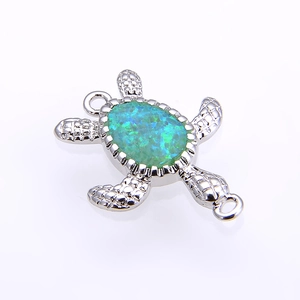 Dettaglio del ciondolo a tartaruga con intarsio in opale blu-verde e metallo argento