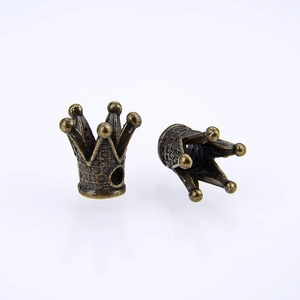 Makro-Detail von Vintage-Bronze-Kronenanhängern mit strukturierter Oberfläche und Löchern