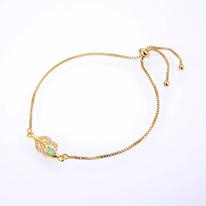 Macro detail of leaf-shaped bracelet charm with opal inlay and micro-pave crystals