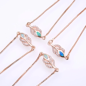 Detail of rose gold leaf bracelets with opal inlay and cubic zirconia pave on a white background